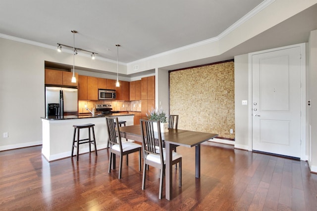 300 St Joseph Pkwy Unit 318, Houston, TX 77002 - dining space featuring dark wood finished floors, crown molding, baseboards, and track lighting