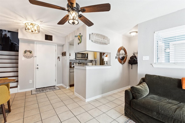 kitchen with kitchen peninsula, ceiling fan, light tile patterned flooring, and white cabinets