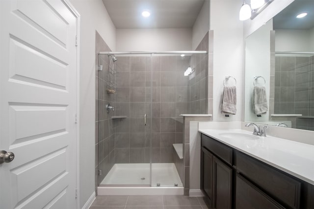 bathroom featuring tile patterned flooring, vanity, and an enclosed shower