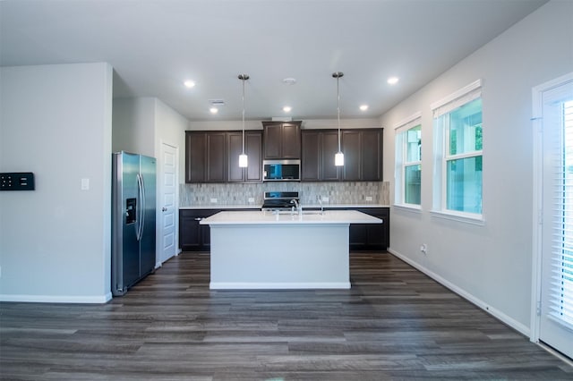 kitchen with a healthy amount of sunlight, hanging light fixtures, and appliances with stainless steel finishes