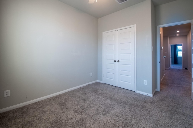 unfurnished bedroom featuring ceiling fan, a closet, and carpet floors