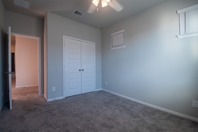 unfurnished bedroom with ceiling fan, dark carpet, and a closet