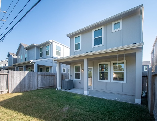 rear view of property with a yard, a patio area, and central air condition unit