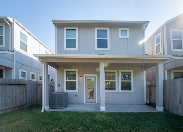 back of property featuring a lawn, a patio, and central AC unit