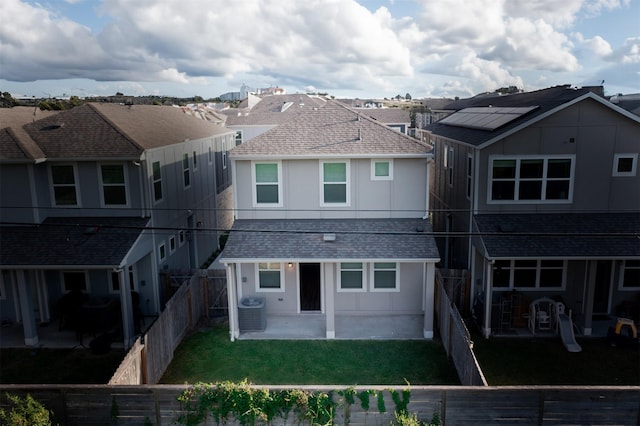 rear view of house featuring a lawn, cooling unit, and a patio