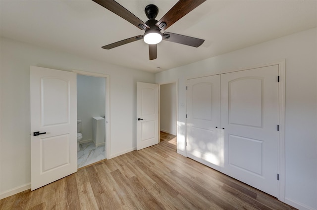 unfurnished bedroom featuring a closet, light hardwood / wood-style floors, ensuite bath, and ceiling fan