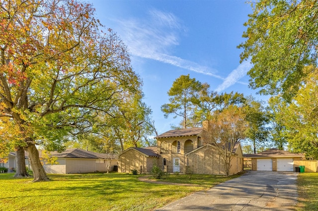 view of front of property featuring a garage, a balcony, and a front yard