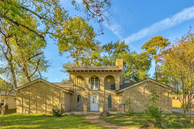 view of front of house featuring a balcony and a front yard