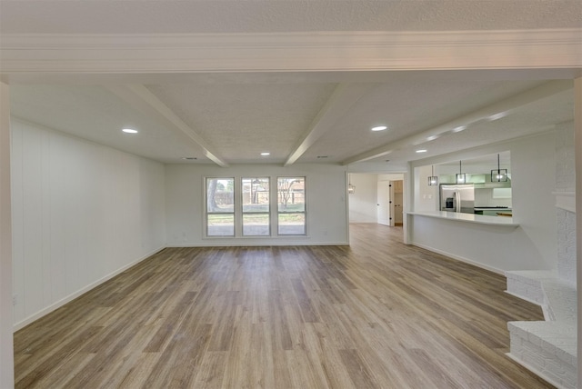 unfurnished living room featuring beam ceiling, a textured ceiling, and hardwood / wood-style flooring