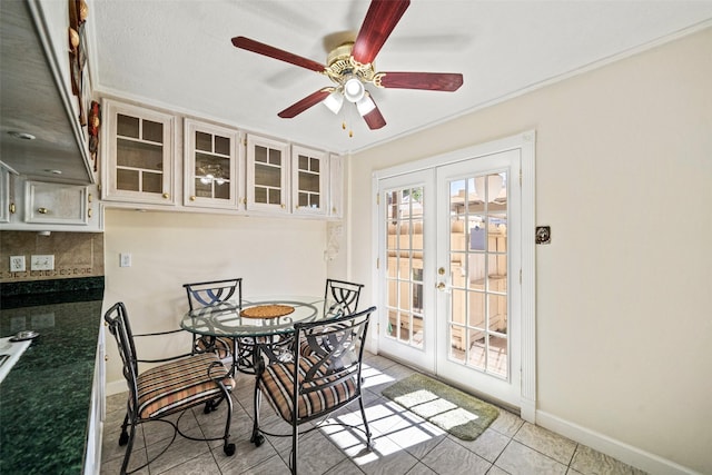 tiled dining area featuring ceiling fan and french doors