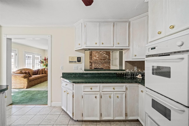 kitchen with white cabinets, french doors, white double oven, and crown molding