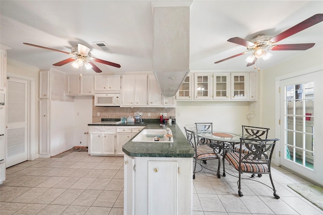 kitchen featuring white cabinets, light tile patterned floors, and sink