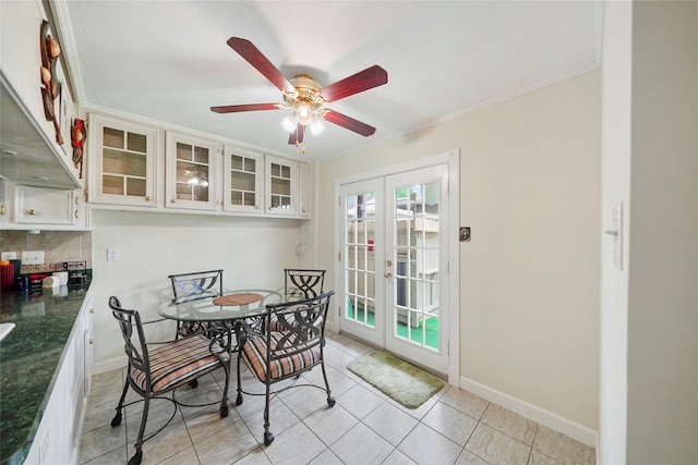 dining room with ceiling fan, french doors, light tile patterned flooring, and crown molding