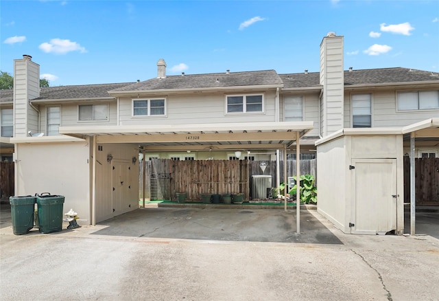 back of house featuring a carport