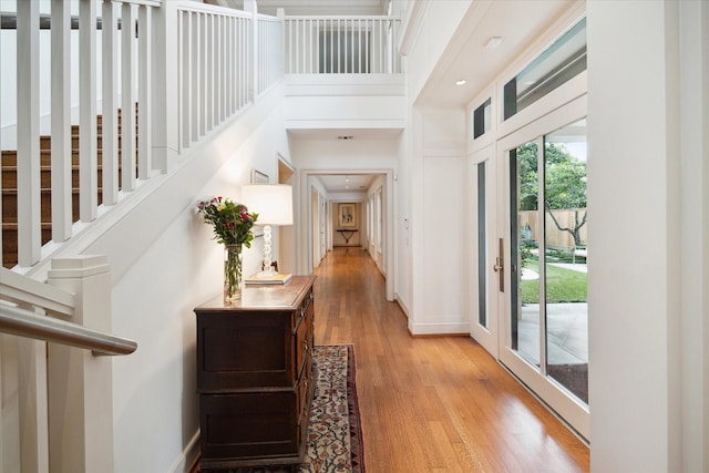 entryway with a towering ceiling and light hardwood / wood-style floors