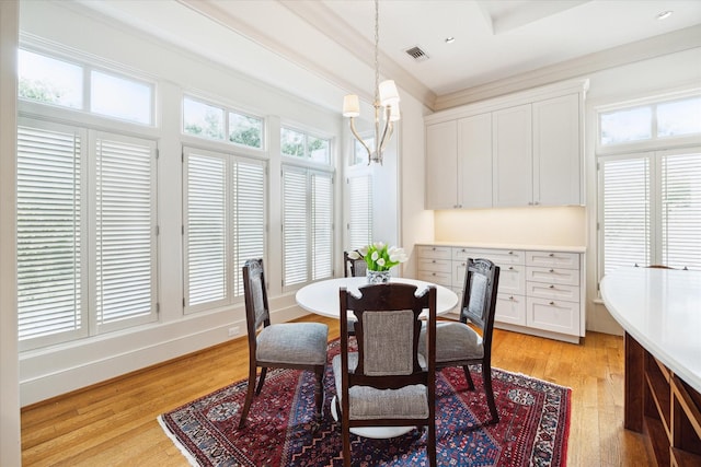 dining room with ornamental molding, a chandelier, and light wood-type flooring