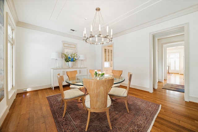 dining room featuring crown molding, dark hardwood / wood-style floors, a wealth of natural light, and a chandelier