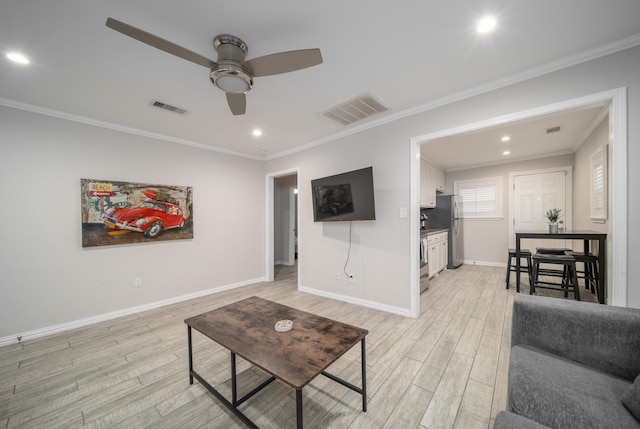 living room with ceiling fan, crown molding, and light hardwood / wood-style flooring