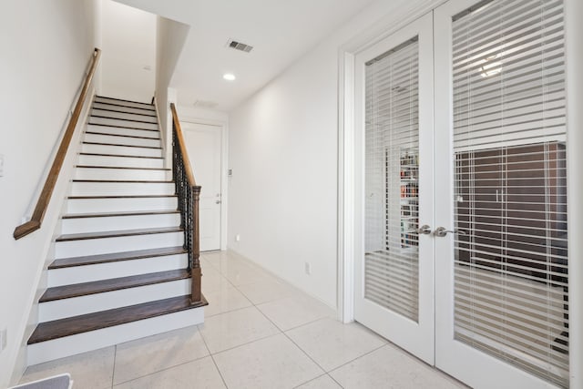 staircase featuring french doors and tile patterned floors