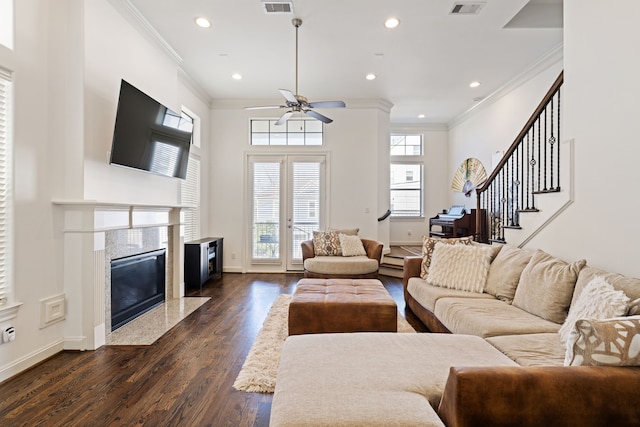 living room with ornamental molding, ceiling fan, dark wood-type flooring, and a premium fireplace