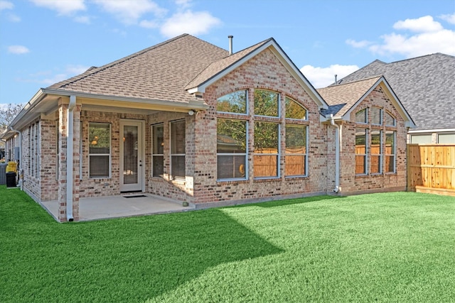 rear view of property with a yard and a patio area