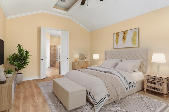 bedroom with crown molding, vaulted ceiling, ceiling fan, connected bathroom, and light hardwood / wood-style floors