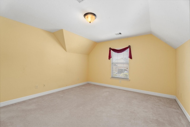 additional living space with light carpet and vaulted ceiling