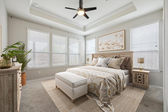 carpeted bedroom with a tray ceiling, ceiling fan, and ornamental molding