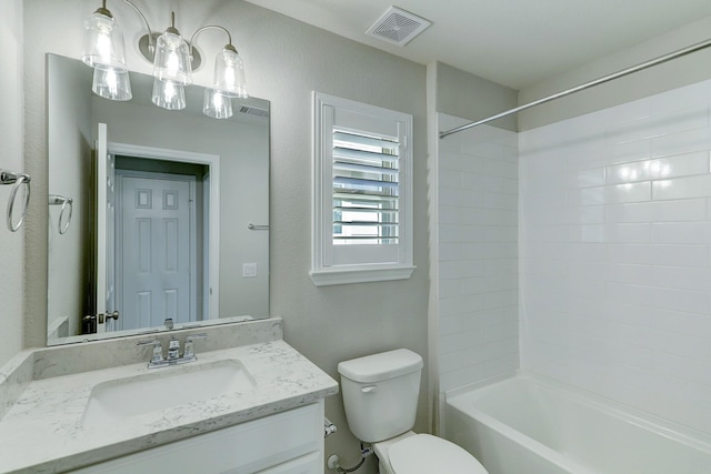 full bathroom featuring tiled shower / bath, vanity, and toilet