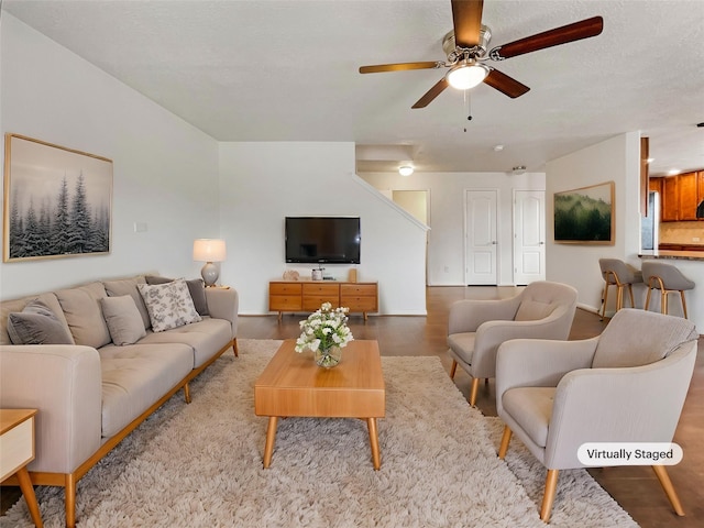 living room featuring ceiling fan and a textured ceiling