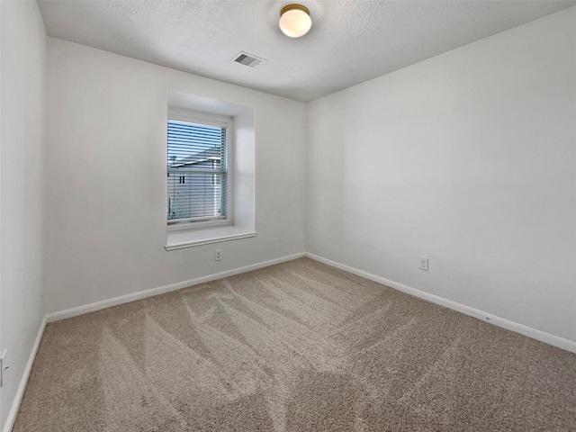 carpeted spare room with a textured ceiling