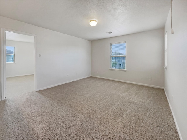 carpeted spare room with a textured ceiling