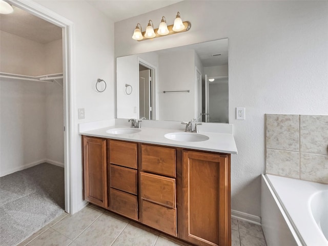 bathroom featuring a tub to relax in, tile patterned flooring, and vanity