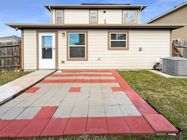 rear view of property with a lawn, a patio area, and cooling unit