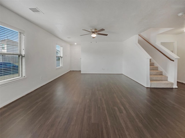 unfurnished living room with ceiling fan, dark hardwood / wood-style flooring, and a textured ceiling