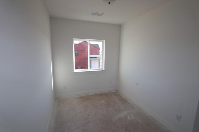 empty room featuring baseboards, unfinished concrete floors, and visible vents