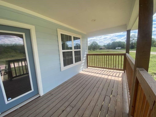 wooden terrace with a lawn