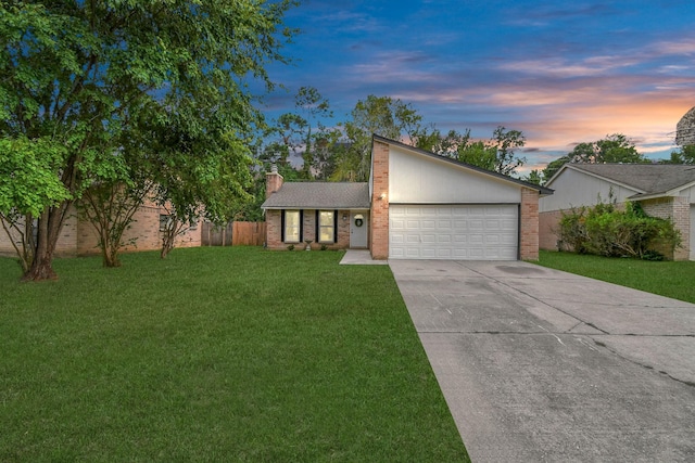 ranch-style house featuring a garage and a yard