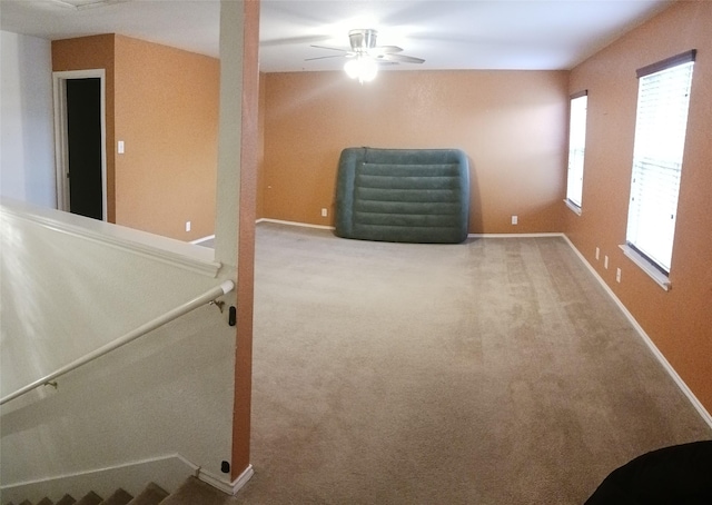 basement featuring carpet flooring and ceiling fan