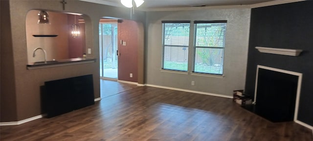 living room featuring crown molding, plenty of natural light, dark wood-type flooring, and sink