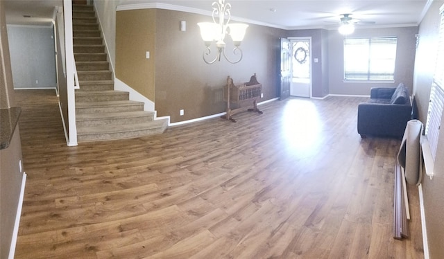 living room featuring crown molding, ceiling fan with notable chandelier, and hardwood / wood-style flooring