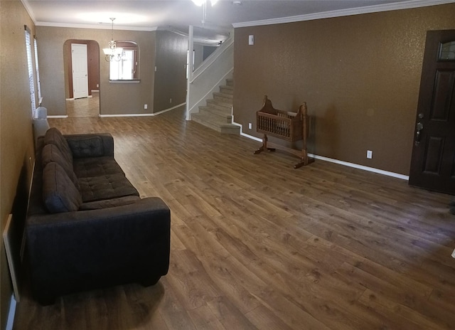 living room with hardwood / wood-style floors, an inviting chandelier, and ornamental molding