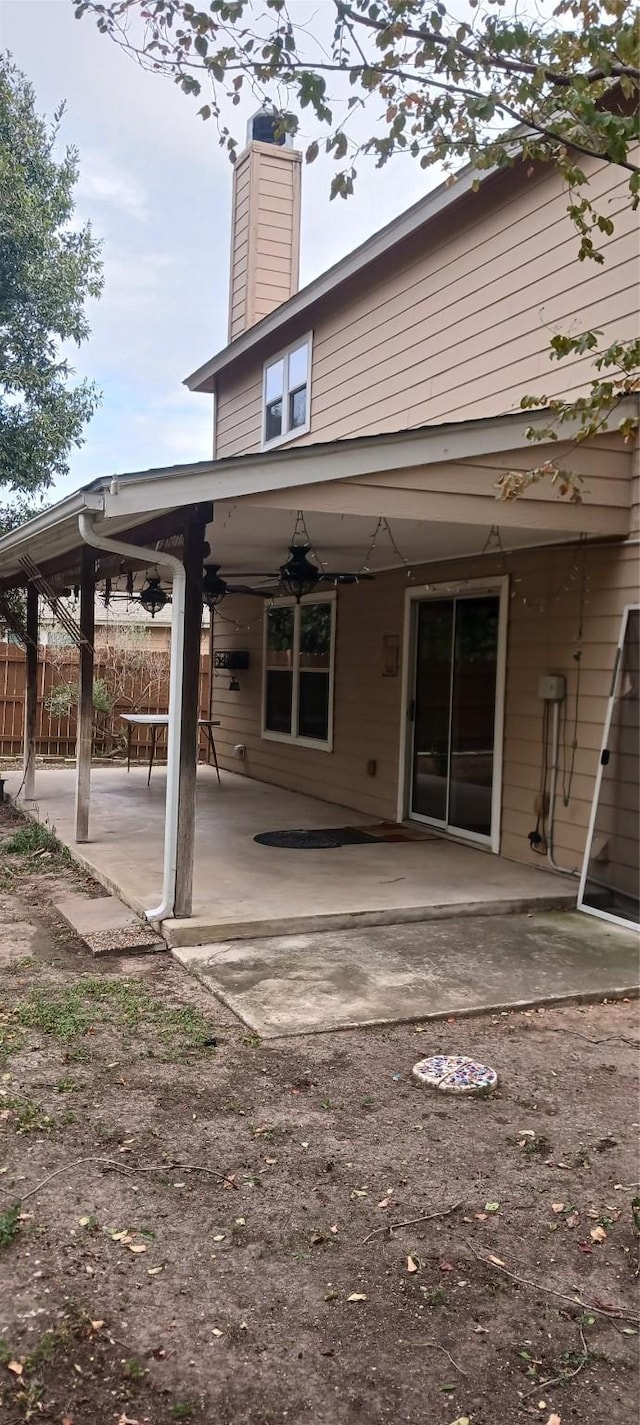 rear view of house with ceiling fan and a patio area