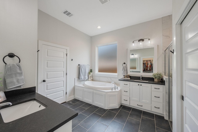 bathroom featuring plus walk in shower, vanity, and tile patterned floors