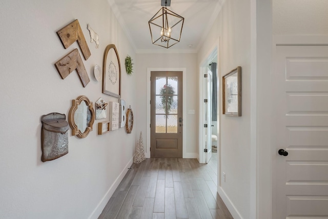 doorway featuring wood-type flooring, ornamental molding, and a notable chandelier