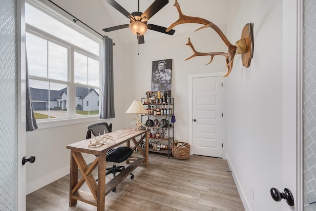 office with light hardwood / wood-style floors and ceiling fan