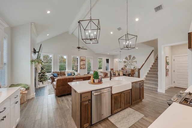 kitchen featuring sink, dishwasher, high vaulted ceiling, pendant lighting, and light wood-type flooring