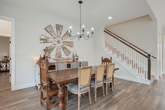 dining room featuring wood-type flooring and an inviting chandelier