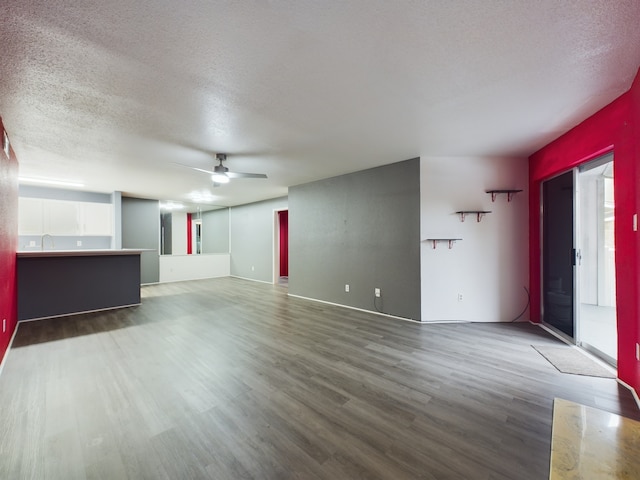 unfurnished living room featuring wood-type flooring and a textured ceiling