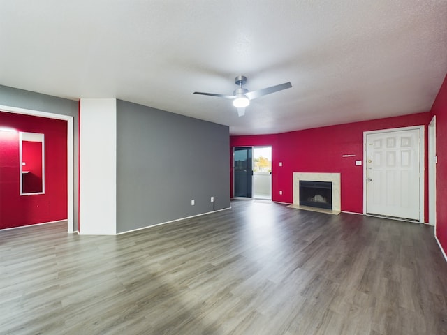 unfurnished living room featuring hardwood / wood-style floors, ceiling fan, and a textured ceiling